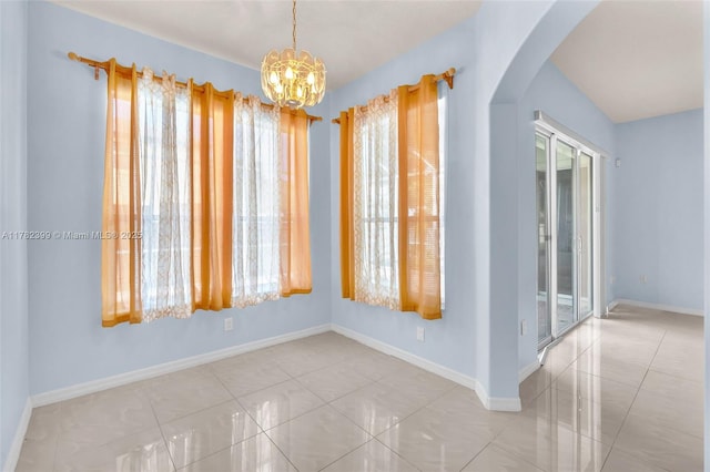 tiled empty room featuring arched walkways, plenty of natural light, and a notable chandelier