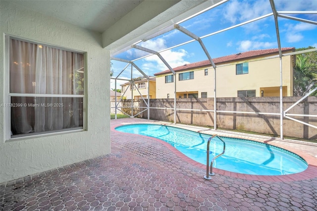 view of swimming pool featuring a fenced in pool, a fenced backyard, a patio area, and a lanai