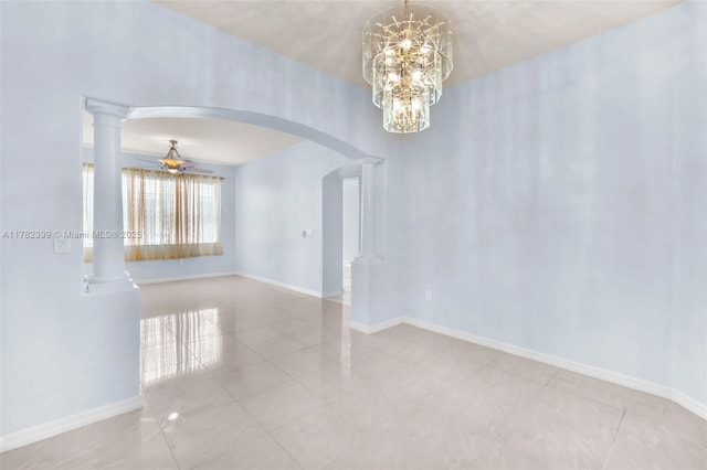spare room featuring tile patterned flooring, baseboards, ornate columns, arched walkways, and ceiling fan with notable chandelier