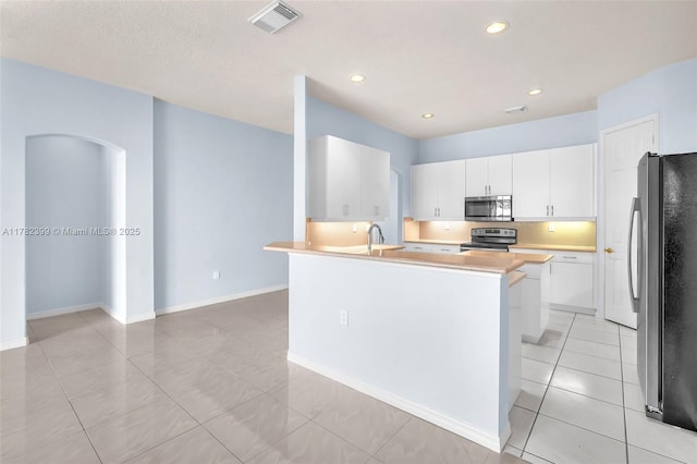 kitchen featuring visible vents, light tile patterned flooring, white cabinets, a sink, and stainless steel appliances