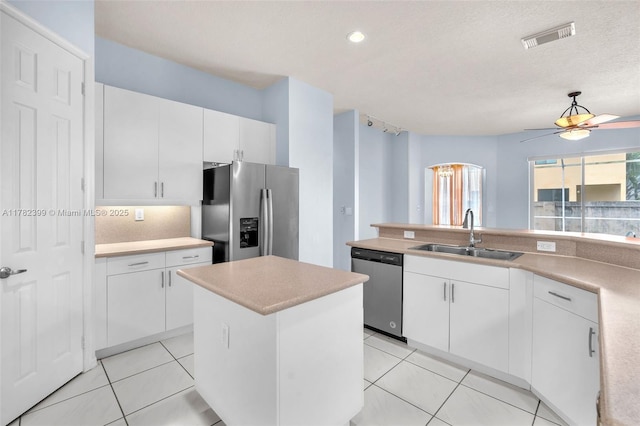 kitchen with ceiling fan, visible vents, appliances with stainless steel finishes, a sink, and light countertops