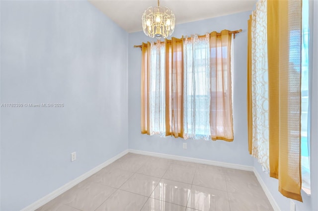 tiled empty room with baseboards and a chandelier