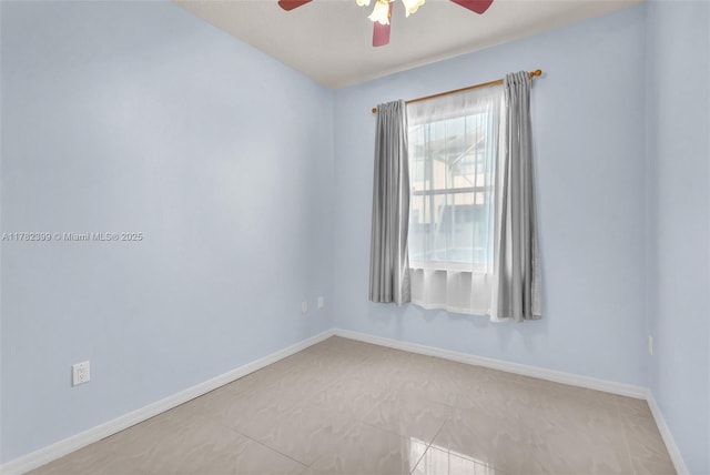 empty room with light tile patterned floors, ceiling fan, and baseboards