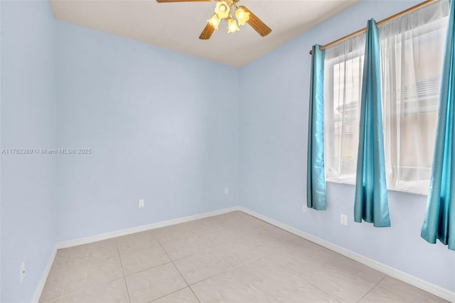 empty room with baseboards, a ceiling fan, and light tile patterned flooring