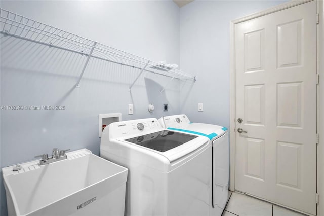 washroom with a sink, laundry area, and independent washer and dryer