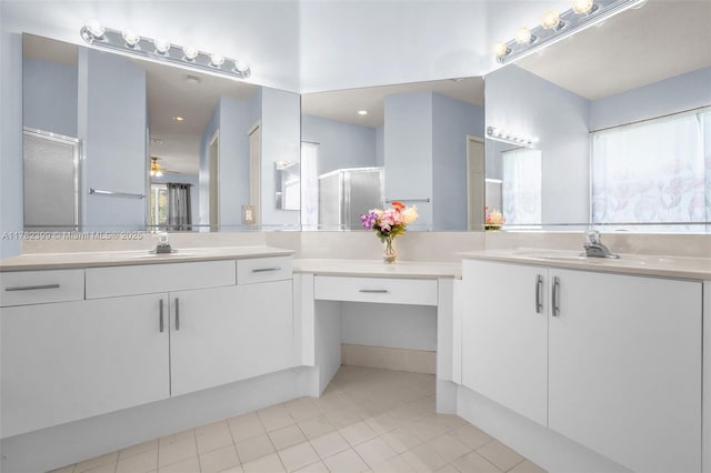 bathroom with a sink, tile patterned flooring, a shower stall, and two vanities