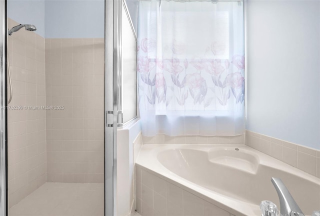full bathroom with plenty of natural light, a shower stall, and a bath