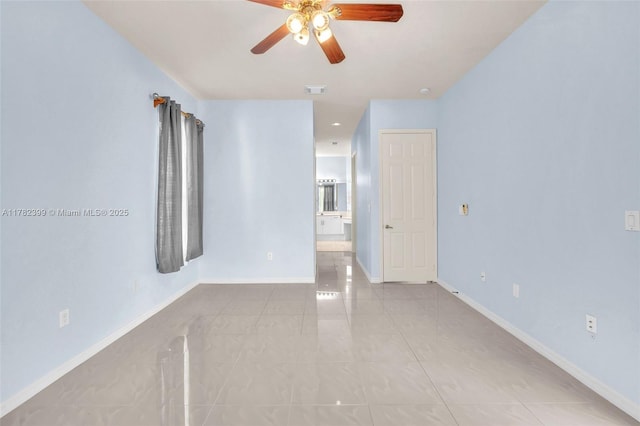 tiled spare room with baseboards, a ceiling fan, and visible vents