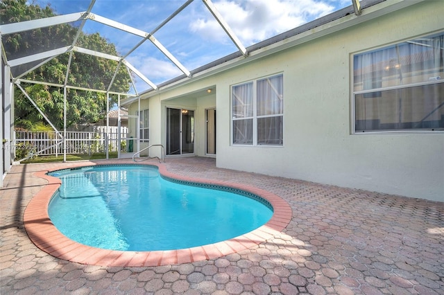 view of swimming pool with a fenced in pool, glass enclosure, and a patio area