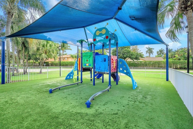 community jungle gym with fence and a yard