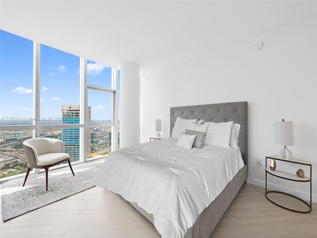 851 NE 1st Ave Ph 5500, Miami, FL 33132 - bedroom with a view of city, expansive windows, light wood finished floors, and baseboards