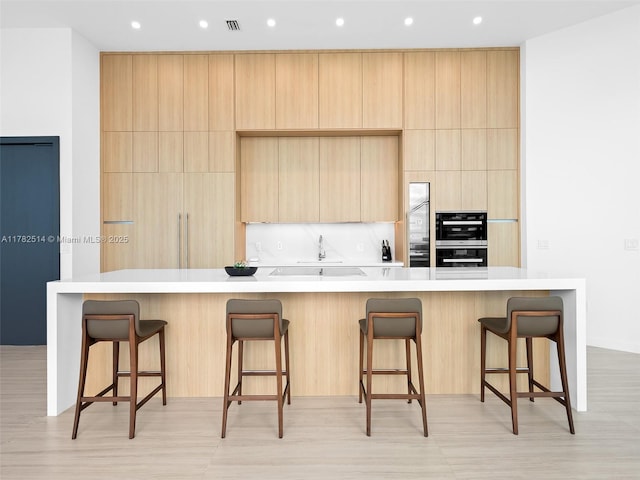 851 NE 1st Ave Ph 5500, Miami, FL 33132 - kitchen with recessed lighting, light brown cabinets, a breakfast bar area, light countertops, and modern cabinets