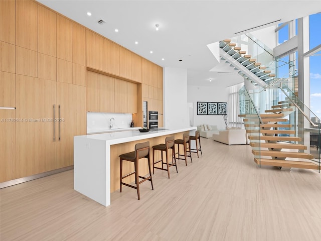 851 NE 1st Ave Ph 5500, Miami, FL 33132 - kitchen with a sink, modern cabinets, a breakfast bar area, a spacious island, and open floor plan