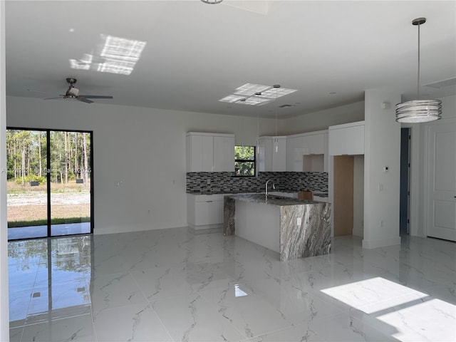 1316 Broadway Ave, Lehigh Acres, FL 33972 - kitchen with modern cabinets, baseboards, healthy amount of natural light, and tasteful backsplash