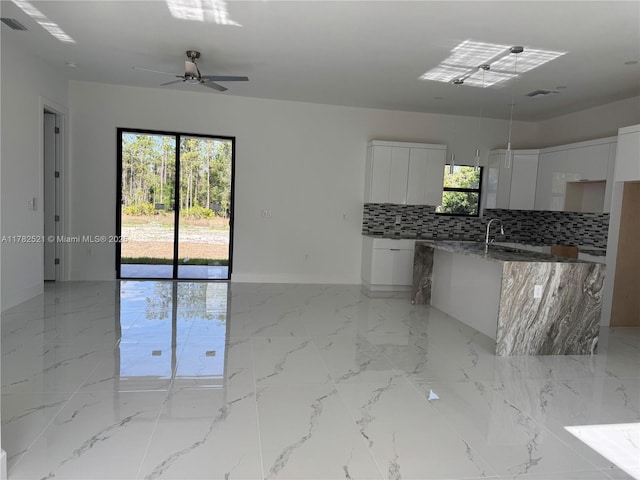 1316 Broadway Ave, Lehigh Acres, FL 33972 - kitchen with modern cabinets, backsplash, white cabinets, and baseboards