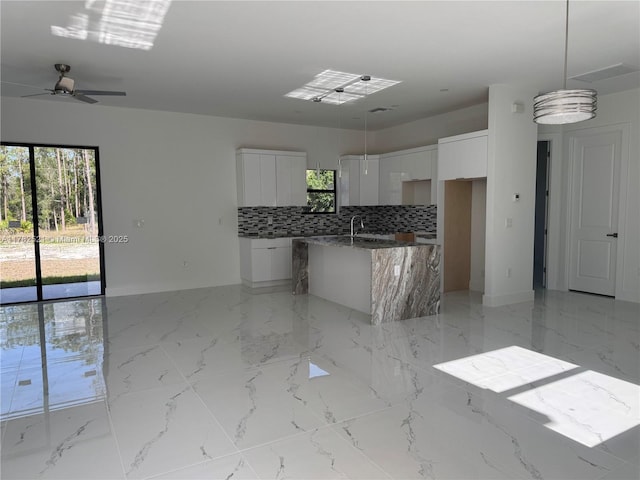 1316 Broadway Ave, Lehigh Acres, FL 33972 - kitchen featuring modern cabinets, baseboards, backsplash, white cabinets, and a ceiling fan