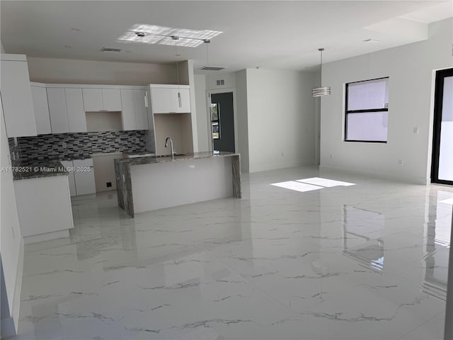 1316 Broadway Ave, Lehigh Acres, FL 33972 - kitchen with tasteful backsplash, modern cabinets, white cabinets, a sink, and a center island