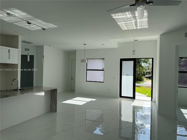 1316 Broadway Ave, Lehigh Acres, FL 33972 - unfurnished living room featuring a sink, ceiling fan, and light marble finish flooring