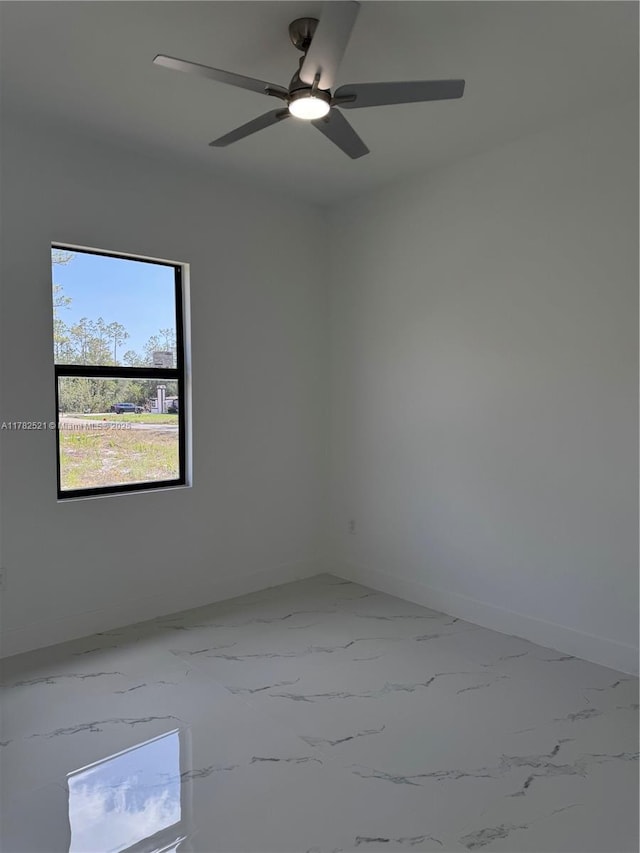 1316 Broadway Ave, Lehigh Acres, FL 33972 - unfurnished room with baseboards, marble look tile flooring, and ceiling fan