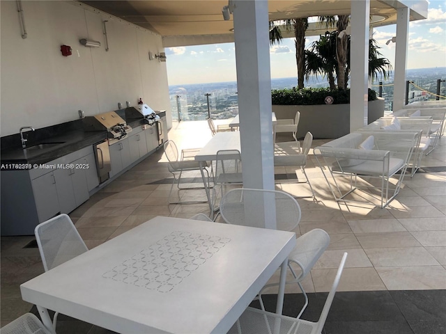 view of patio / terrace with outdoor dining space, a grill, a sink, and exterior kitchen