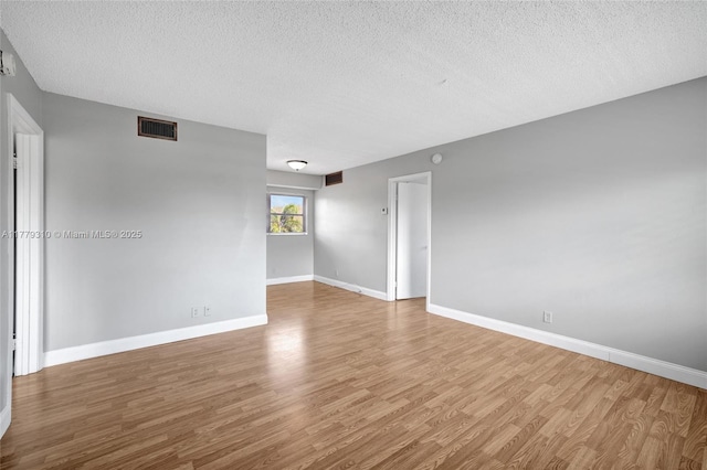 609 NE 13th Ave Unit 301, Fort Lauderdale, FL 33304 - empty room with visible vents, baseboards, wood finished floors, and a textured ceiling