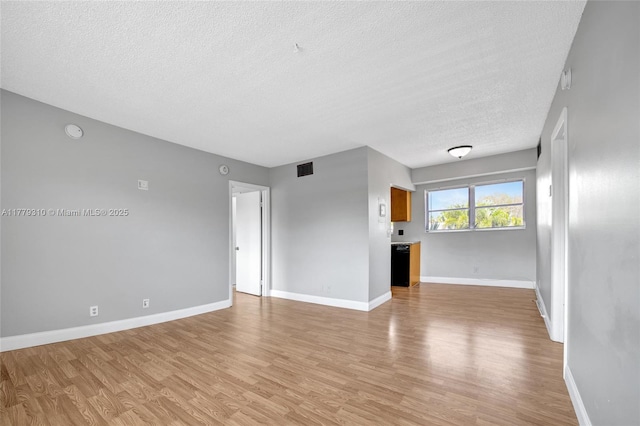 609 NE 13th Ave Unit 301, Fort Lauderdale, FL 33304 - unfurnished living room featuring light wood-style floors, a textured ceiling, and baseboards