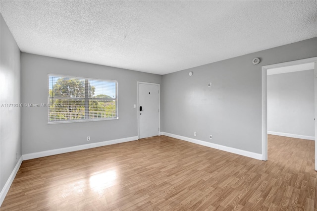 609 NE 13th Ave Unit 301, Fort Lauderdale, FL 33304 - spare room with a textured ceiling, light wood finished floors, and baseboards