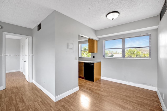 609 NE 13th Ave Unit 301, Fort Lauderdale, FL 33304 - kitchen with visible vents, black dishwasher, light countertops, light wood-style floors, and a textured ceiling