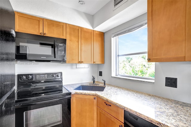 609 NE 13th Ave Unit 301, Fort Lauderdale, FL 33304 - kitchen with visible vents, a sink, black appliances, and light stone counters