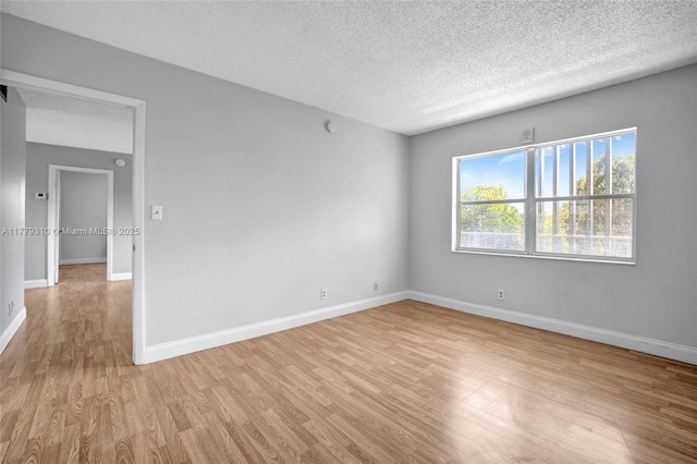 609 NE 13th Ave Unit 301, Fort Lauderdale, FL 33304 - spare room featuring light wood-style flooring, a textured ceiling, and baseboards