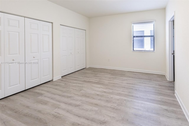 10572 W 35th Way, Hialeah, FL 33018 - unfurnished bedroom with multiple closets and light wood-type flooring