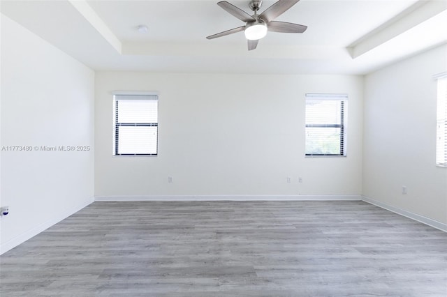 10572 W 35th Way, Hialeah, FL 33018 - spare room with a tray ceiling, healthy amount of natural light, ceiling fan, and light wood-style floors