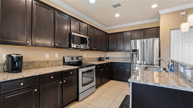 kitchen with light tile patterned floors, a sink, ornamental molding, appliances with stainless steel finishes, and light stone countertops
