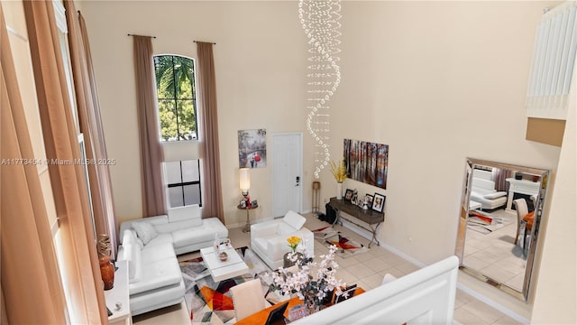 living room with tile patterned floors, a high ceiling, and baseboards