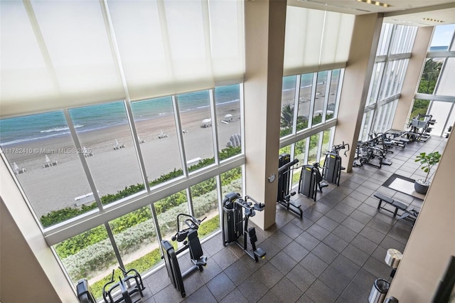 1850 S Ocean Dr Unit 1709, Hallandale Beach, FL 33009 - exercise room featuring a beach view, a towering ceiling, expansive windows, and a water view