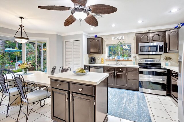 1780 SW 51st Ter, Plantation, FL 33317 - kitchen featuring stainless steel appliances, light countertops, dark brown cabinetry, a sink, and ornamental molding