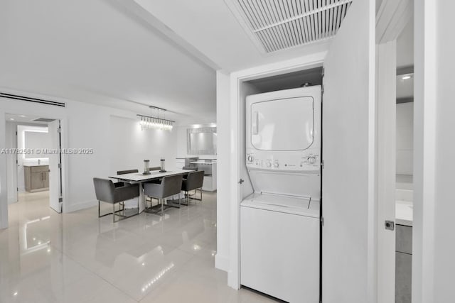 3140 S Ocean Dr Unit 1011, Hallandale Beach, FL 33009 - laundry room with laundry area, light tile patterned floors, visible vents, stacked washer and clothes dryer, and baseboards