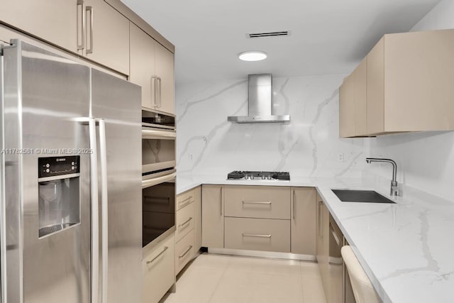 3140 S Ocean Dr Unit 1011, Hallandale Beach, FL 33009 - kitchen featuring wall chimney exhaust hood, light stone countertops, visible vents, a sink, and stainless steel appliances