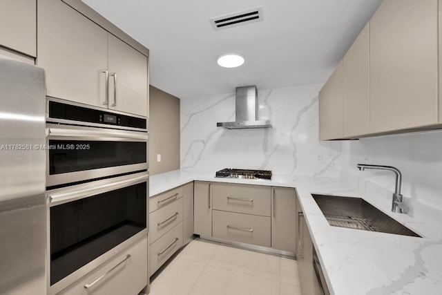 3140 S Ocean Dr Unit 1011, Hallandale Beach, FL 33009 - kitchen with visible vents, wall chimney exhaust hood, a sink, appliances with stainless steel finishes, and light stone countertops