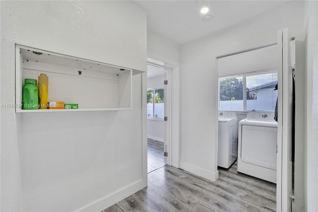 14310 SW 289th St, Homestead, FL 33033 - clothes washing area featuring washing machine and clothes dryer, baseboards, wood finished floors, and laundry area