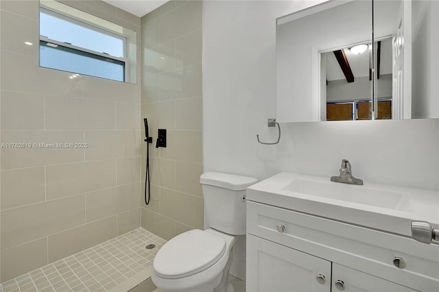 bathroom with toilet, vanity, and a tile shower