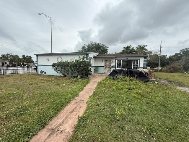 18300 NW 10th Ct, Miami Gardens, FL 33169 - view of front facade with a front yard, fence, and stucco siding