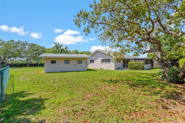 16901 SW 89th Ave, Palmetto Bay, FL 33157 - rear view of property featuring a yard, fence, a sunroom, and stucco siding