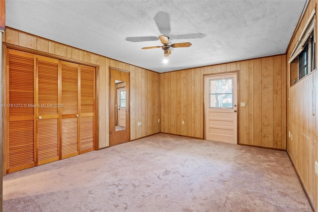 16901 SW 89th Ave, Palmetto Bay, FL 33157 - unfurnished bedroom with wood walls, carpet flooring, a textured ceiling, and ceiling fan