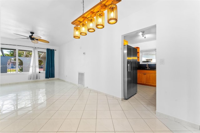 spare room featuring a sink, light tile patterned flooring, baseboards, visible vents, and ceiling fan