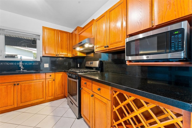 kitchen featuring decorative backsplash, under cabinet range hood, stainless steel appliances, and a sink