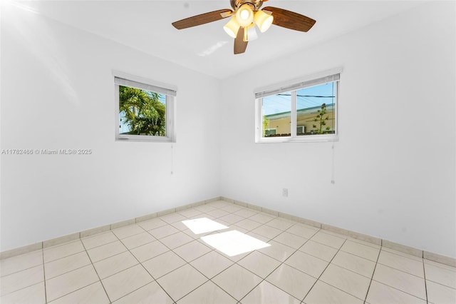 unfurnished room with ceiling fan, baseboards, and light tile patterned floors