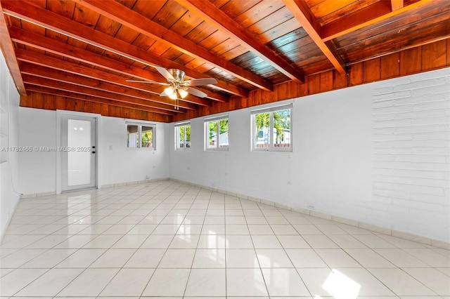 empty room featuring wooden ceiling, beam ceiling, ceiling fan, and light tile patterned floors