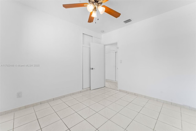 empty room with light tile patterned floors, visible vents, and ceiling fan