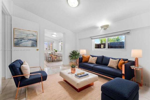 living room featuring lofted ceiling and light tile patterned floors
